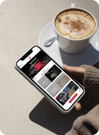 Personne tenant un smartphone avec une tasse de café